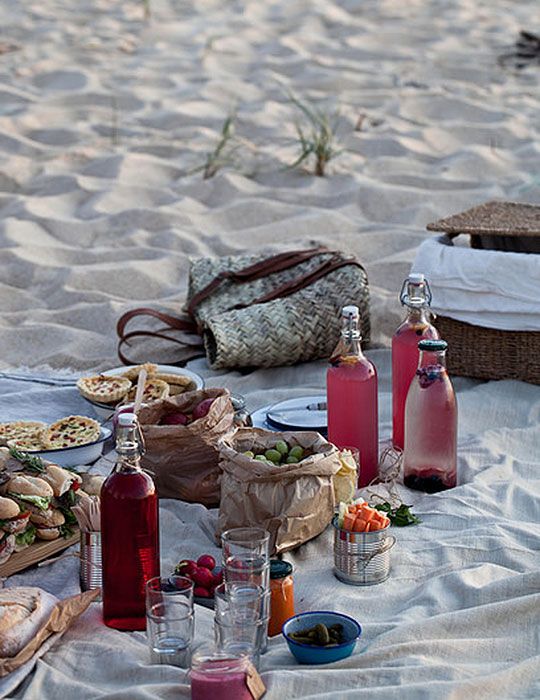 a picnic on the beach with food and drinks