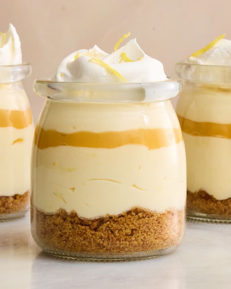 three jars filled with dessert sitting on top of a table