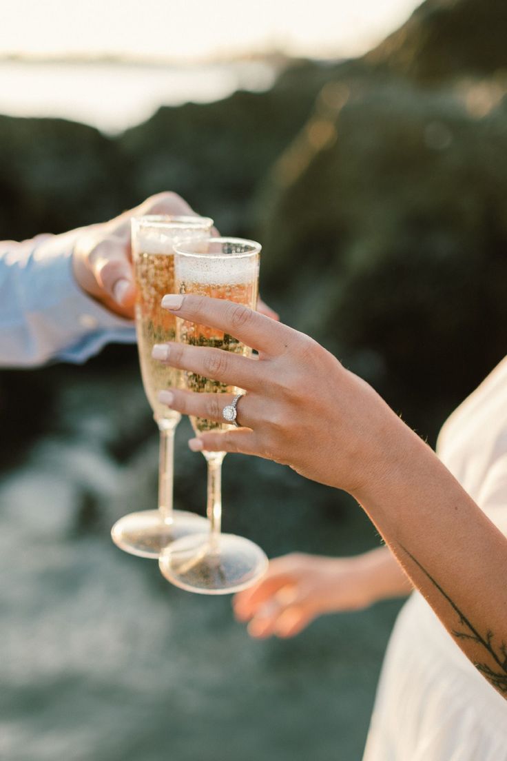 two people holding wine glasses in their hands