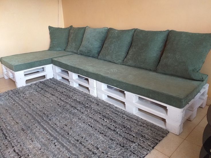 a couch made out of wooden pallets sitting on top of a rug