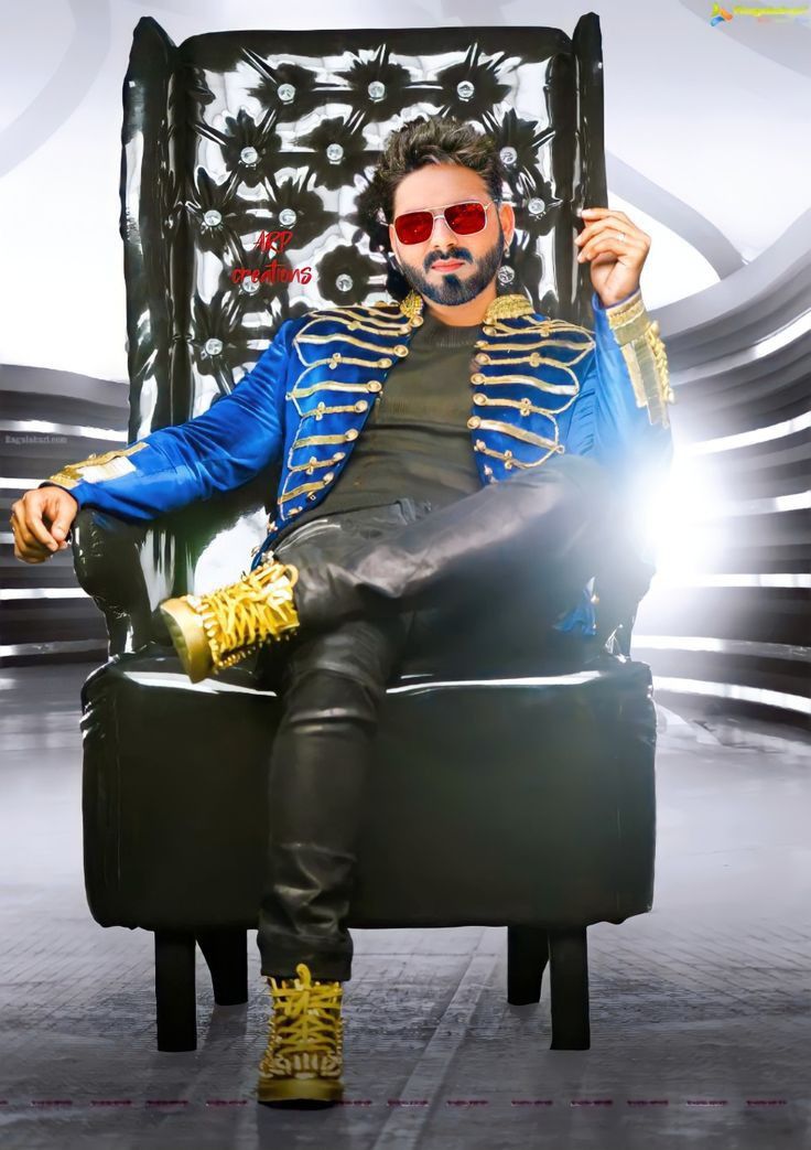 a man sitting on top of a chair in a blue jacket and gold shoes with sunglasses