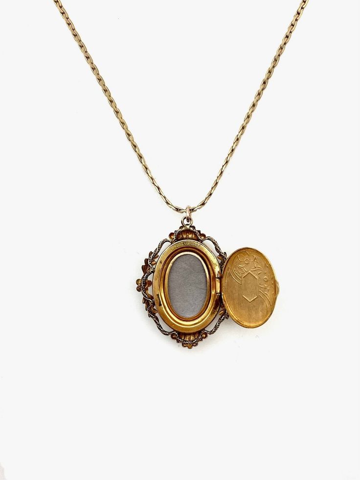 Indulge in timeless elegance with this rare antique cameo locket. Crafted in 12k gold-fill, this exquisite piece exudes charm and nostalgia. The oval shape, measuring 1.5 cm in width and 2 cm in length, showcases meticulous craftsmanship, featuring a detailed carved cameo and etched floral back. Stamped Van Dell, indicating the piece is from the 1940s, and made in Rhode Island. This vintage gem is not just a locket; it's a piece of art that transcends eras. The secure click-shut mechanism ensure Antique Gold Keepsake Pendant Jewelry, Antique Gold Pendant Jewelry For Keepsake, Victorian Yellow Gold Pendant Locket Necklace, Victorian Yellow Gold Locket Necklace For Formal Occasions, Bronze Oval Pendant Jewelry With Antique Finish, Bronze Oval Pendant With Antique Finish, Bronze Antique Finish Oval Pendant Jewelry, Victorian Filigree Yellow Gold Locket Necklace, Victorian Yellow Gold Locket Necklace With Filigree