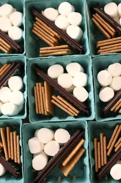 several trays filled with marshmallows and pretzels on top of each other