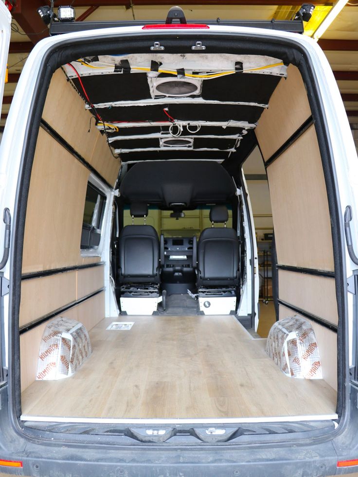 the back end of a van with its doors open and wood flooring in place