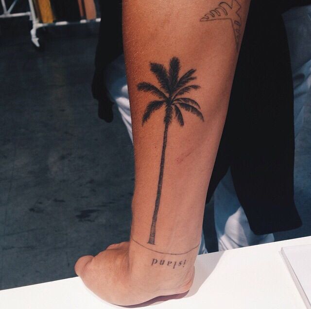 a person with a palm tree tattoo on their leg