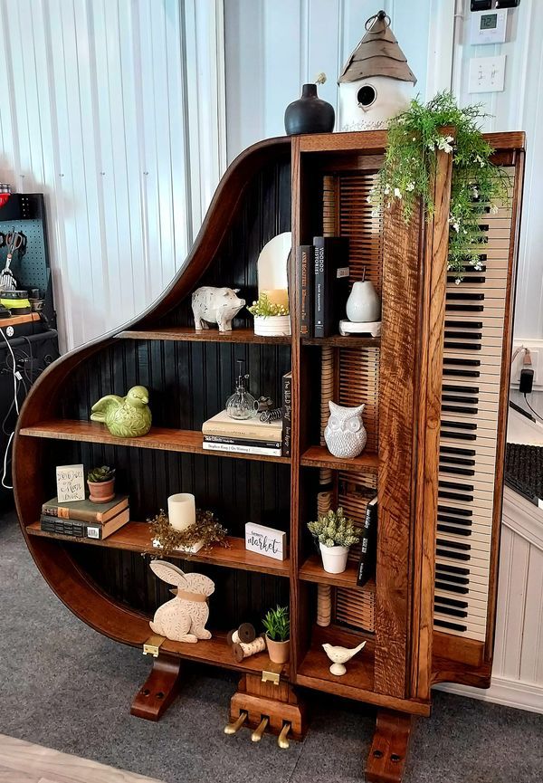 a book shelf with books, plants and other items on it in a living room