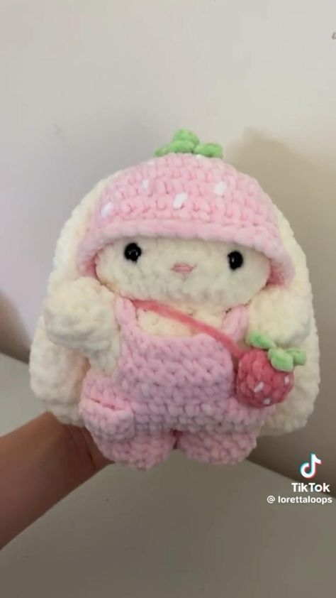 a small stuffed animal is wearing a pink outfit