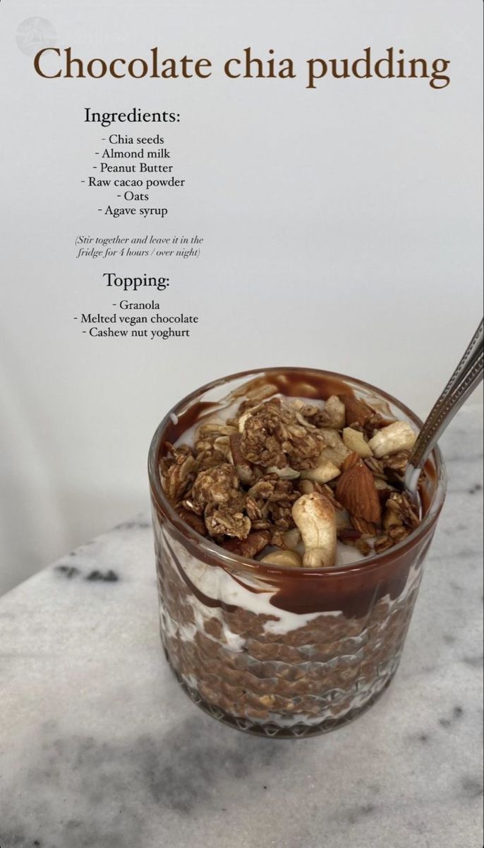 chocolate chia pudding in a glass with nuts and almonds on top, sitting on a marble table