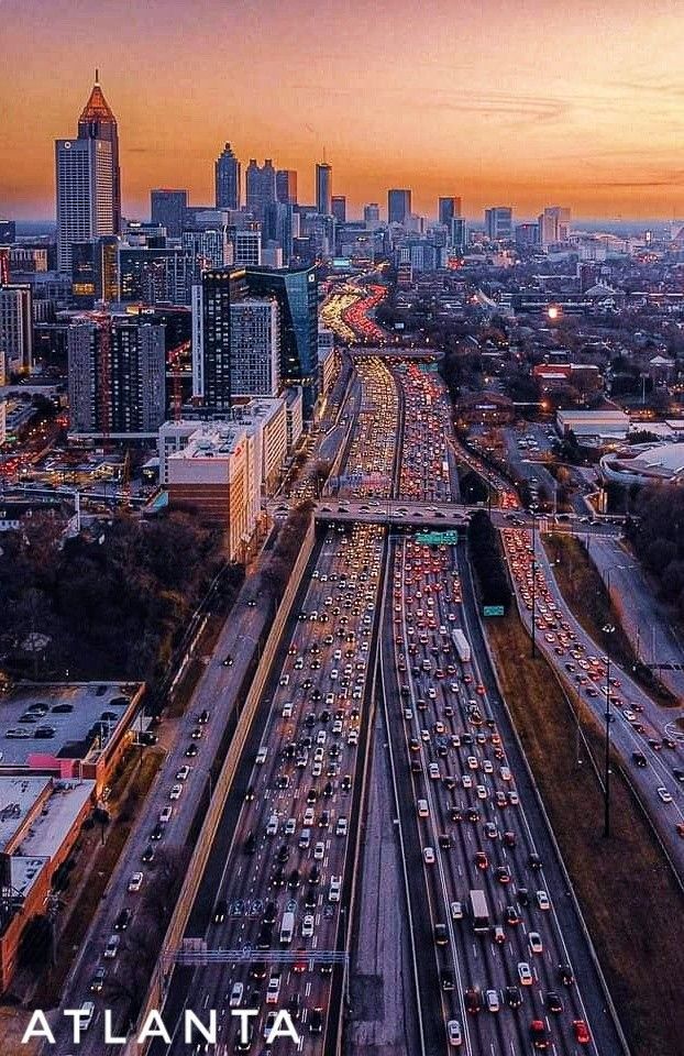 an aerial view of the atlanta skyline at sunset with traffic jams on both sides