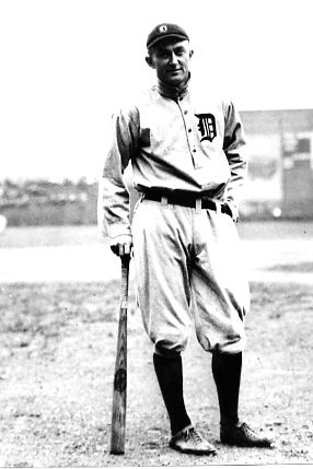 an old black and white photo of a baseball player with a bat in his hand