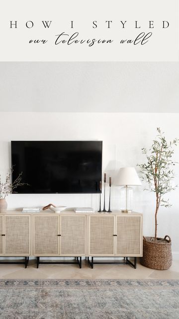 a living room with a large television mounted on the wall