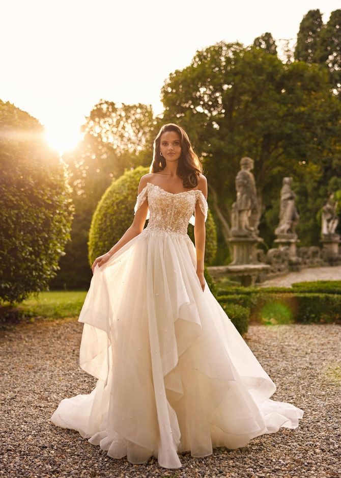 a woman in a wedding dress posing for the camera with her hands on her hips