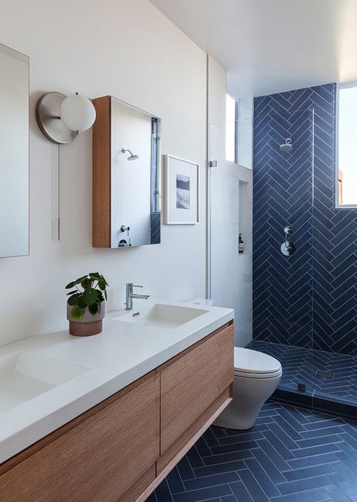 a bathroom with two sinks, a toilet and a walk in shower area is shown