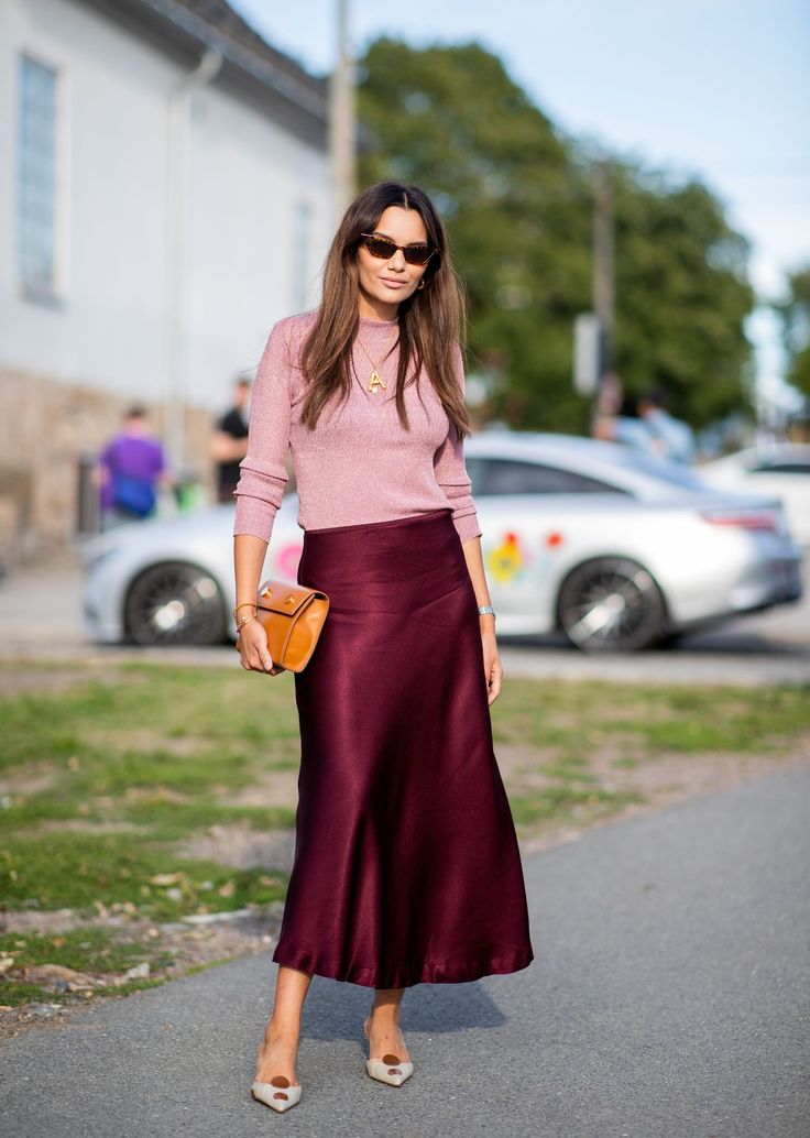 Give The Slip- Trade in your go-to pencil skirt for a midi slip skirt that works just as well with a sweater as it does with a blazer and blouse. Satin Skirt Street Style, Silk Skirt Outfit, Looks Adidas, Satin Skirt Outfit, Maroon Skirt, Rok Outfit, Walking Down The Street, Burgundy Skirt, Slip Skirts