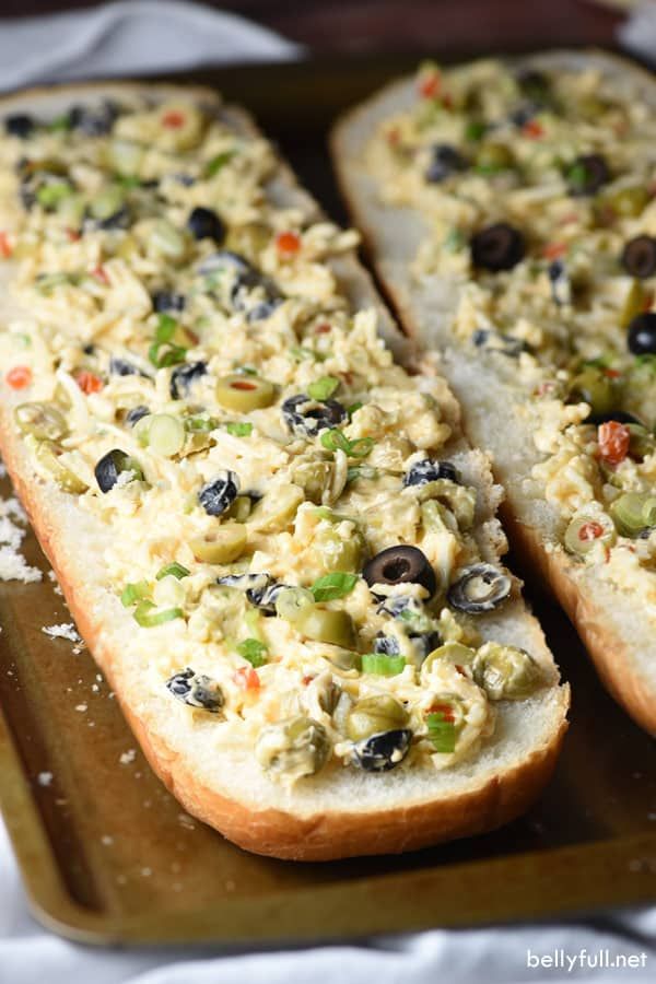 two pieces of bread with olives and other toppings