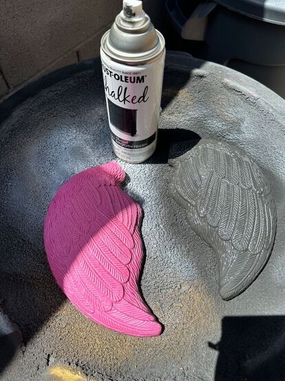 a spray can sitting on top of a table next to a pink object