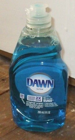 a bottle of dawn water sitting on the floor