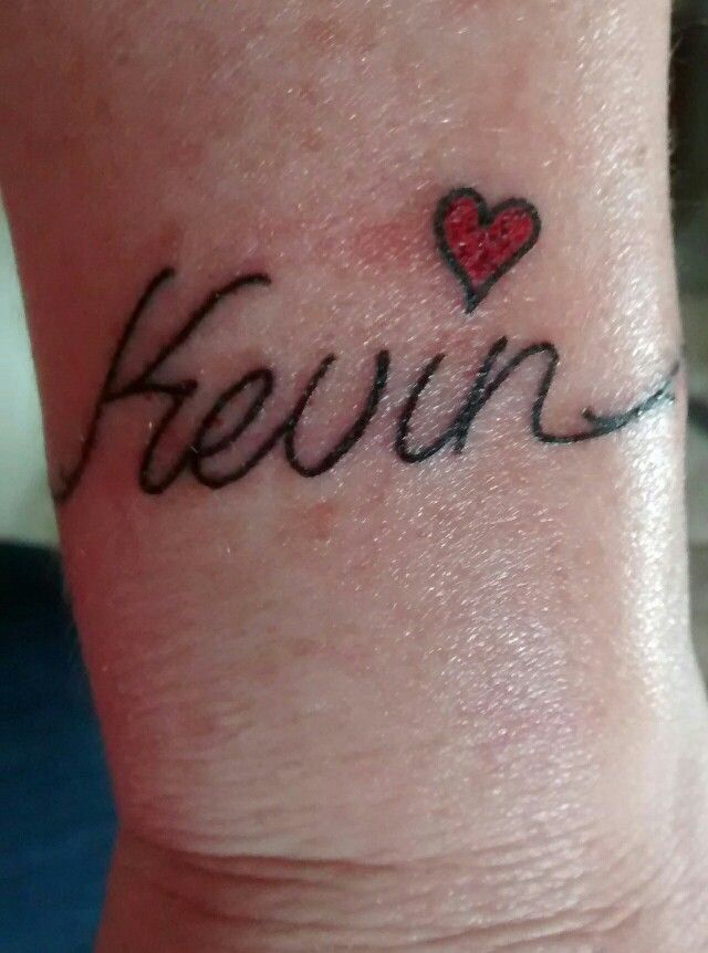 a small wrist tattoo with the word fewn written in cursive writing