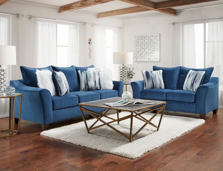 a living room with blue couches and pillows