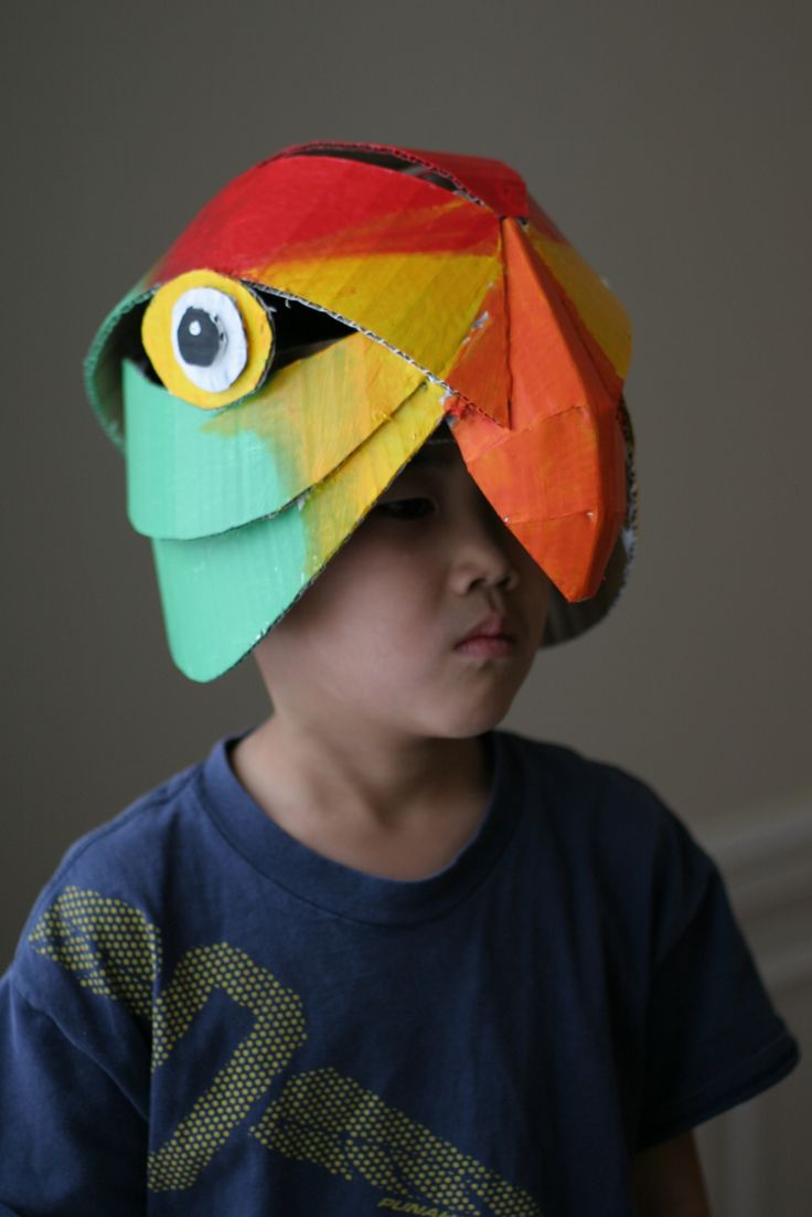 a young boy wearing a paper hat with googly eyes