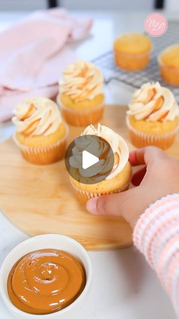 a person is holding a cupcake in front of some cupcakes