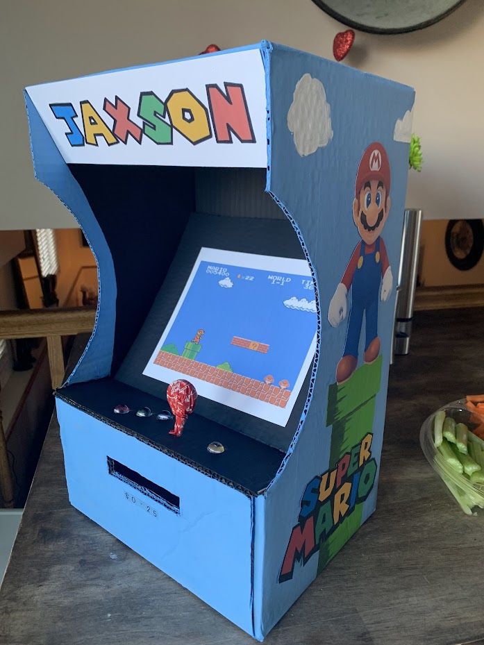 an arcade machine sitting on top of a table next to a bowl of carrots