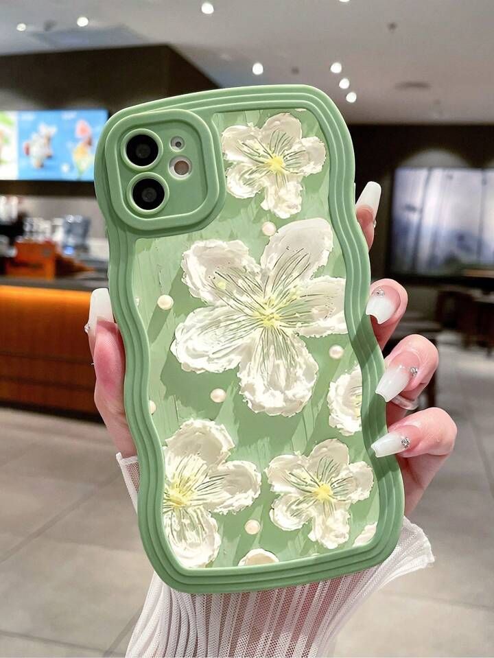 a woman holding up a phone case with flowers on it