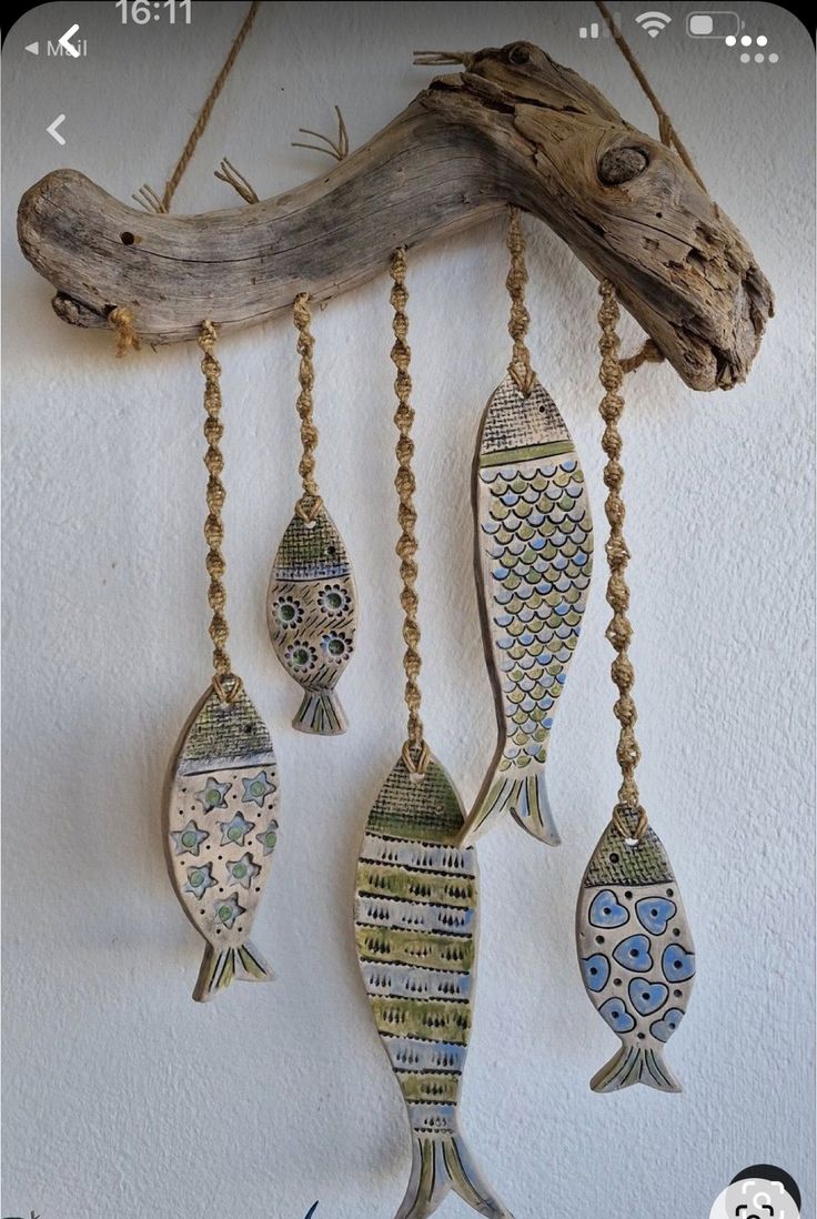 three fish hanging from chains on a wall