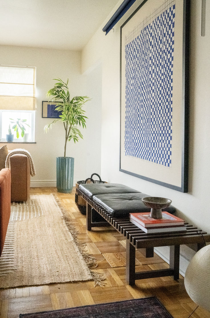 a living room filled with furniture and a large painting hanging on the wall above it