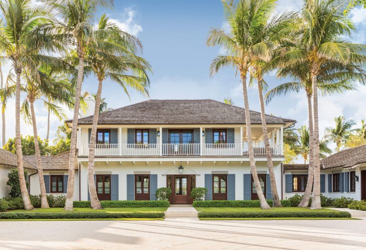 a large white house surrounded by palm trees