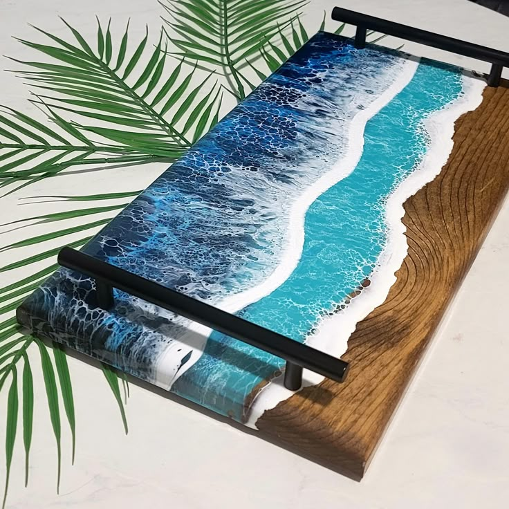 a painting on a wooden board with blue water and white waves coming in from the ocean