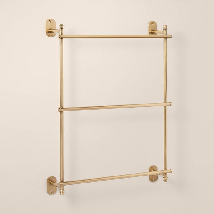 the brass towel rack has two bars on each side and is attached to the wall