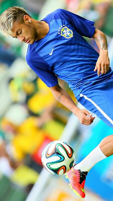 a man kicking a soccer ball in the air with his foot on top of it