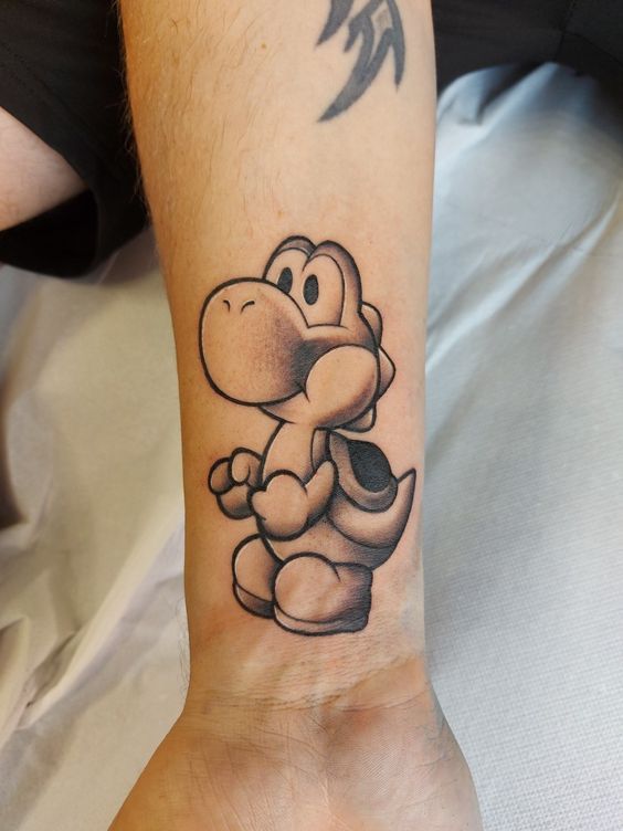 a tattoo on the wrist of a man with a nintendo mario bros character tattooed on his arm