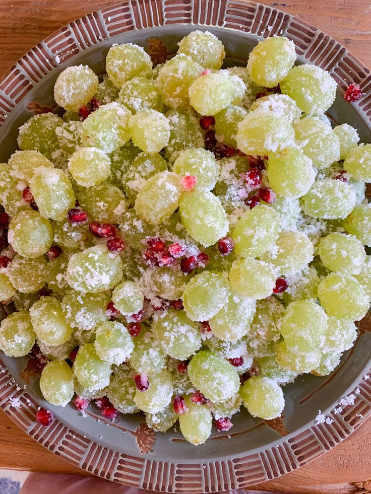 a bowl filled with grapes covered in powdered sugar