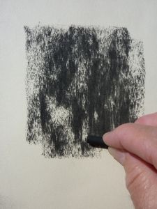 a hand is holding a black marker in front of a white wall