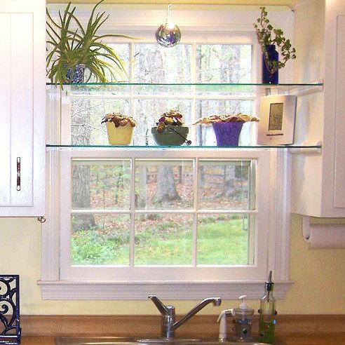 a kitchen with white cabinets and wooden counter tops, along with a window over the sink