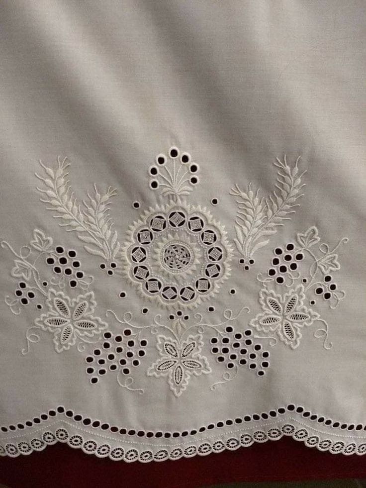 an embroidered white cloth with black dots and flowers