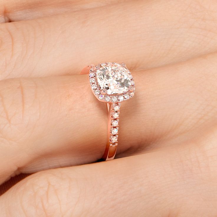 a woman's hand with a diamond ring on top of her finger and an engagement band