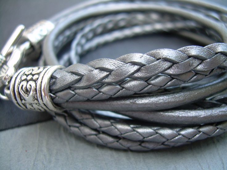 Time to get your shimmer on with this 5 Strand Metallic Gray Silver Leather Bracelet. Wrap it around your wrist twice, toggle and go...A great addition to any jewelry collection. Worn alone, layered or stacked....show them your "Inner Rebel". Materials: Lead and Nickel Free - Aged Silver Toned Alloy Metal Components, Fine Grade 3 and 5mm round and flat braided and 3mm round leather cords. Each piece comes with a brand hang tag and a black drawstring pouch. Size: Available to fit a firm wrist mea Gray Bracelet, Womens Bracelet, Leather Bracelets Women, Multi Strand Bracelet, Chunky Bracelets, Round Leather, Unique Jewelry Designs, Grade 3, Leather Wrap Bracelet