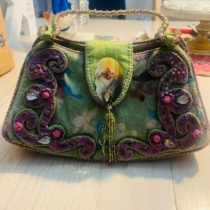 Beautiful Mary Frances Velvet Bag - Beautiful Colors - Greens , Purples , Blues. Very Intricate And In Euc - Worn 1 Time - Statement Piece But Unfortunately Have To Down Size My Bags . Thanks For Stopping By, Comment With Questions And Happy Poshing ! Handmade Handheld Purple Shoulder Bag, Handmade Purple Handheld Shoulder Bag, Green Clutch Bag With Handles, Handmade Purple Clutch Shoulder Bag, Handmade Purple Shoulder Bag For Evening, Handheld Purple Shoulder Bag, Purple Handheld Shoulder Bag, Handmade Purple Satchel Shoulder Bag, Handmade Purple Evening Bag