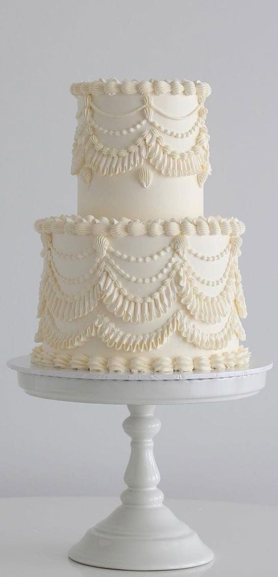 a three - tiered white wedding cake with ruffles