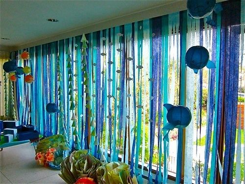 the room is decorated with blue, green and orange streamers hanging from the ceiling