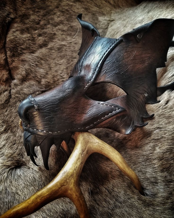 a leather mask with antlers attached to it's face on a fur surface