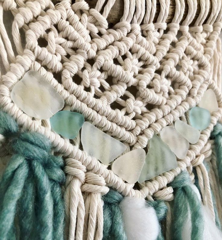 a close up view of some tassels on a piece of woven material that is white and green