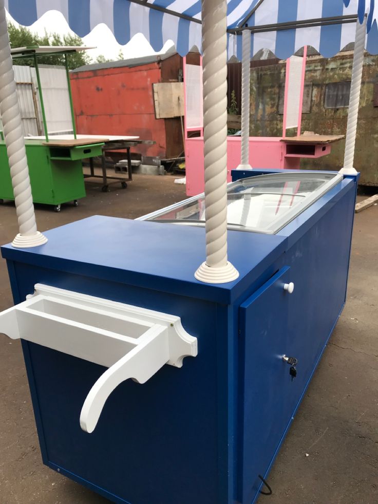 a blue and white cooler sitting under a canopy