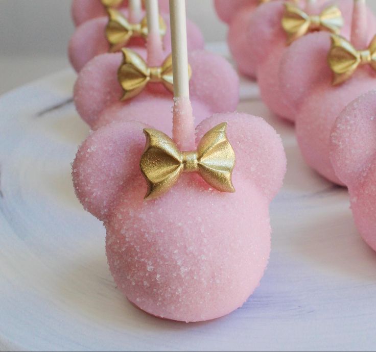 pink and gold mickey mouse marshmallows on a white plate