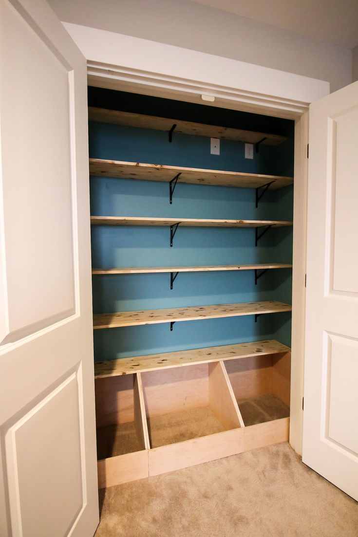 an empty closet with blue walls and shelves