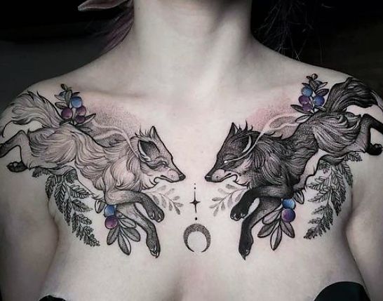 a woman with tattoos on her chest has two foxes and an moon in the middle