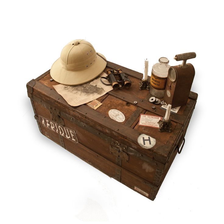 an old trunk with various items on it including a hat, scissors and other things